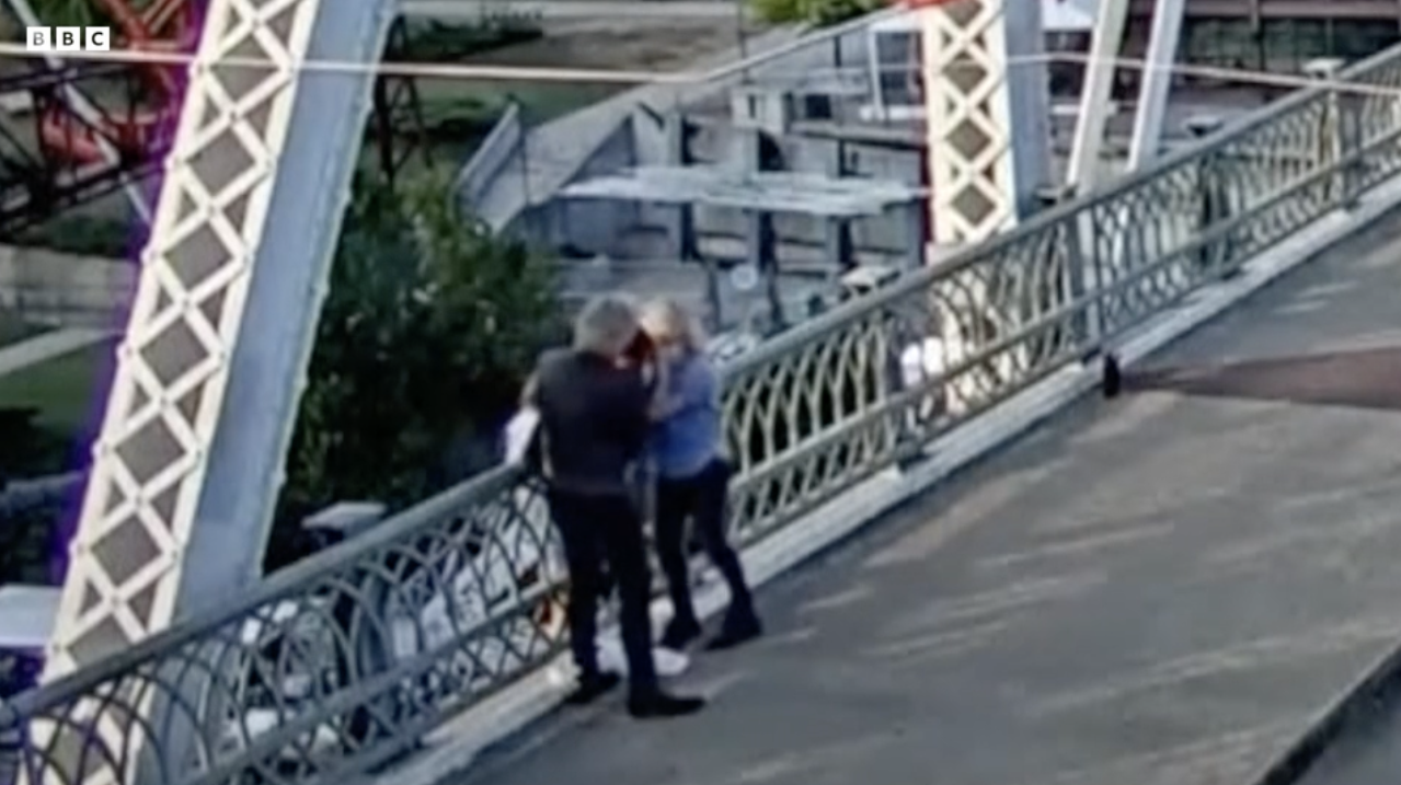 Jon Bon Jovi and friend helping a woman off of a bridge's railing
